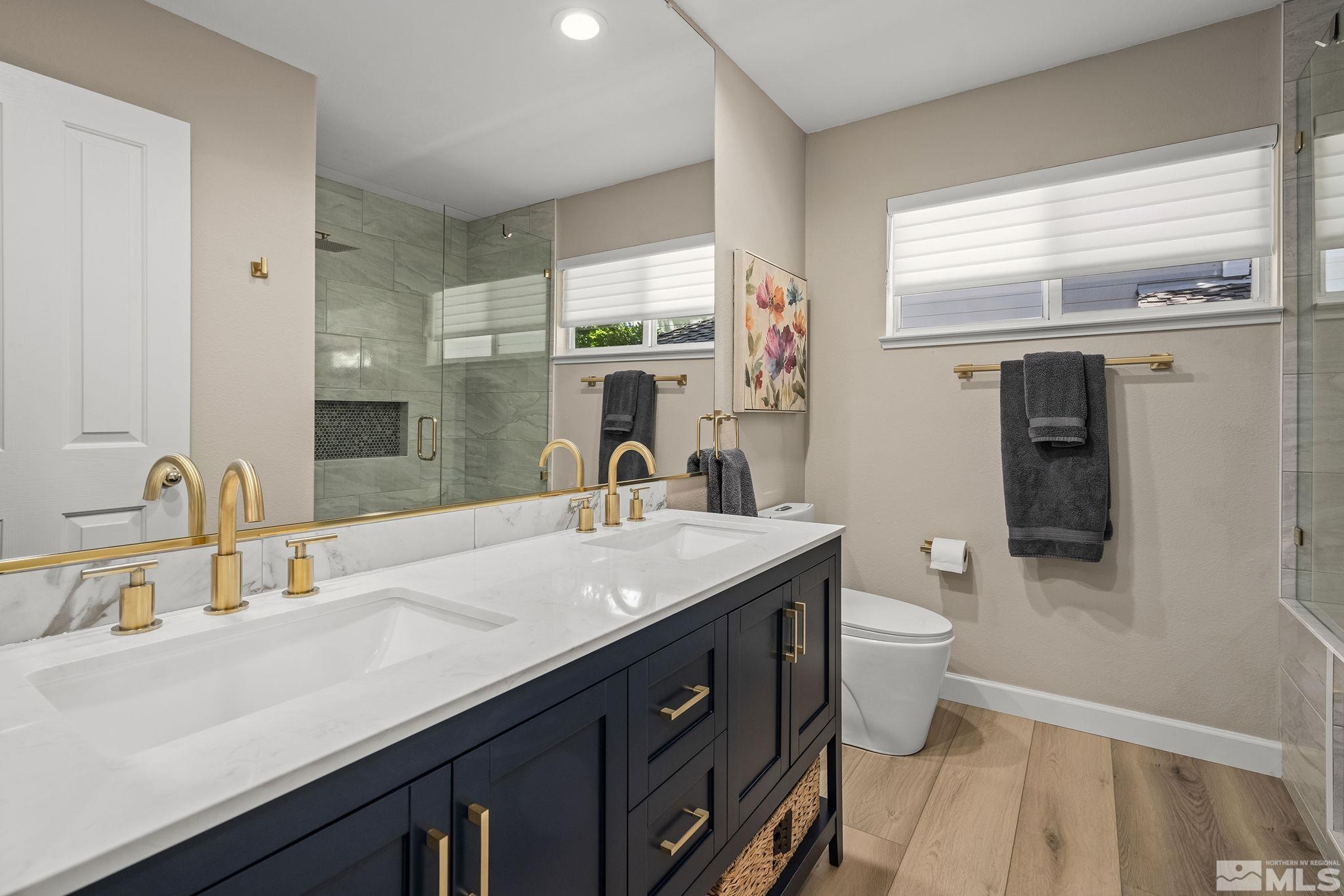 6156 Wycliffe Circle Reno, NV 89519 - Photo 21 of 30 a bathroom with a double vanity sink a mirror and a toilet