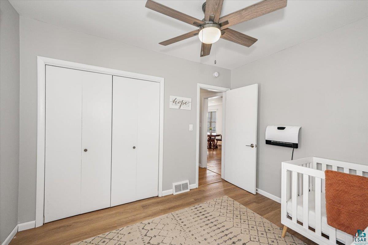 415 14th Street Cloquet, MN 55720 - Photo 10 of 20 Bedroom featuring a crib, light wood finished floors, a closet, and a ceiling fan