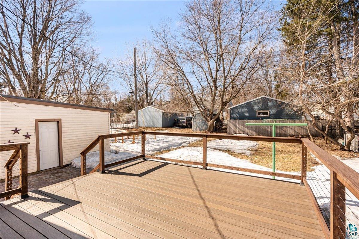 415 14th Street Cloquet, MN 55720 - Photo 14 of 20 Wooden terrace with a storage unit and a fenced backyard