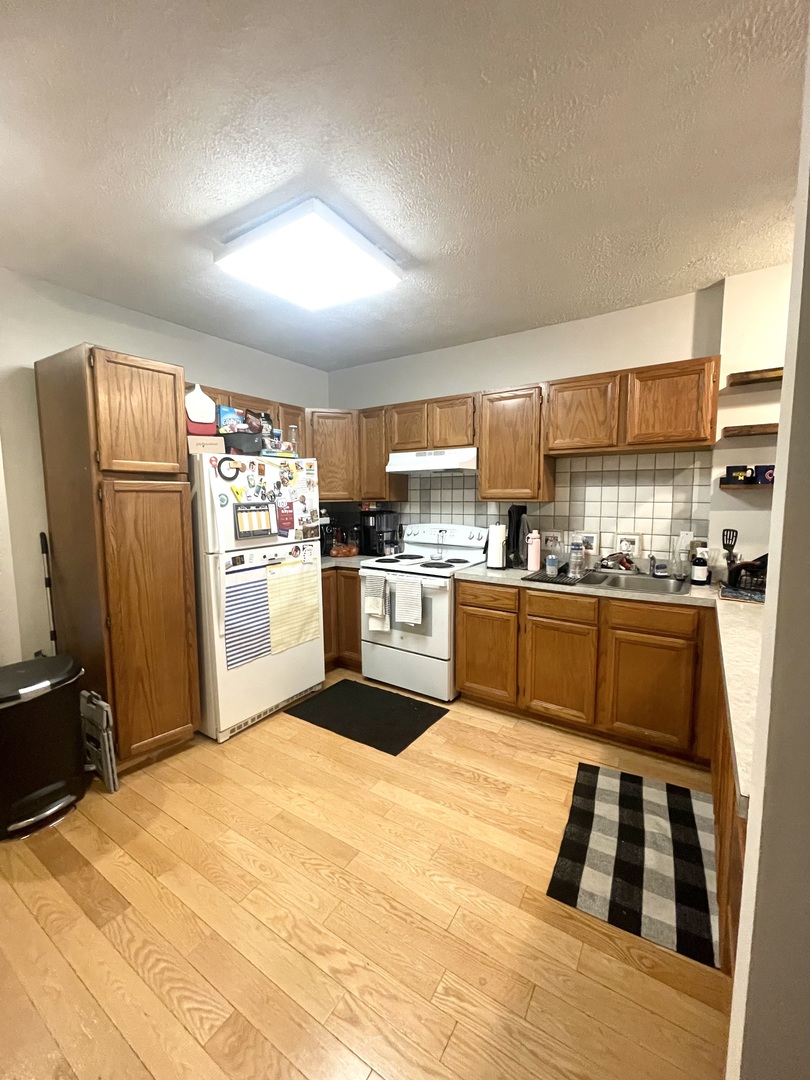 1132 West Addison Street, Unit 2 Chicago, IL 60613 - Photo 7 of 11 a kitchen with granite countertop stainless steel appliances and wooden cabinets