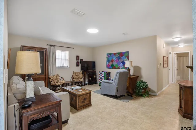 a living room with furniture a flat screen tv and a window