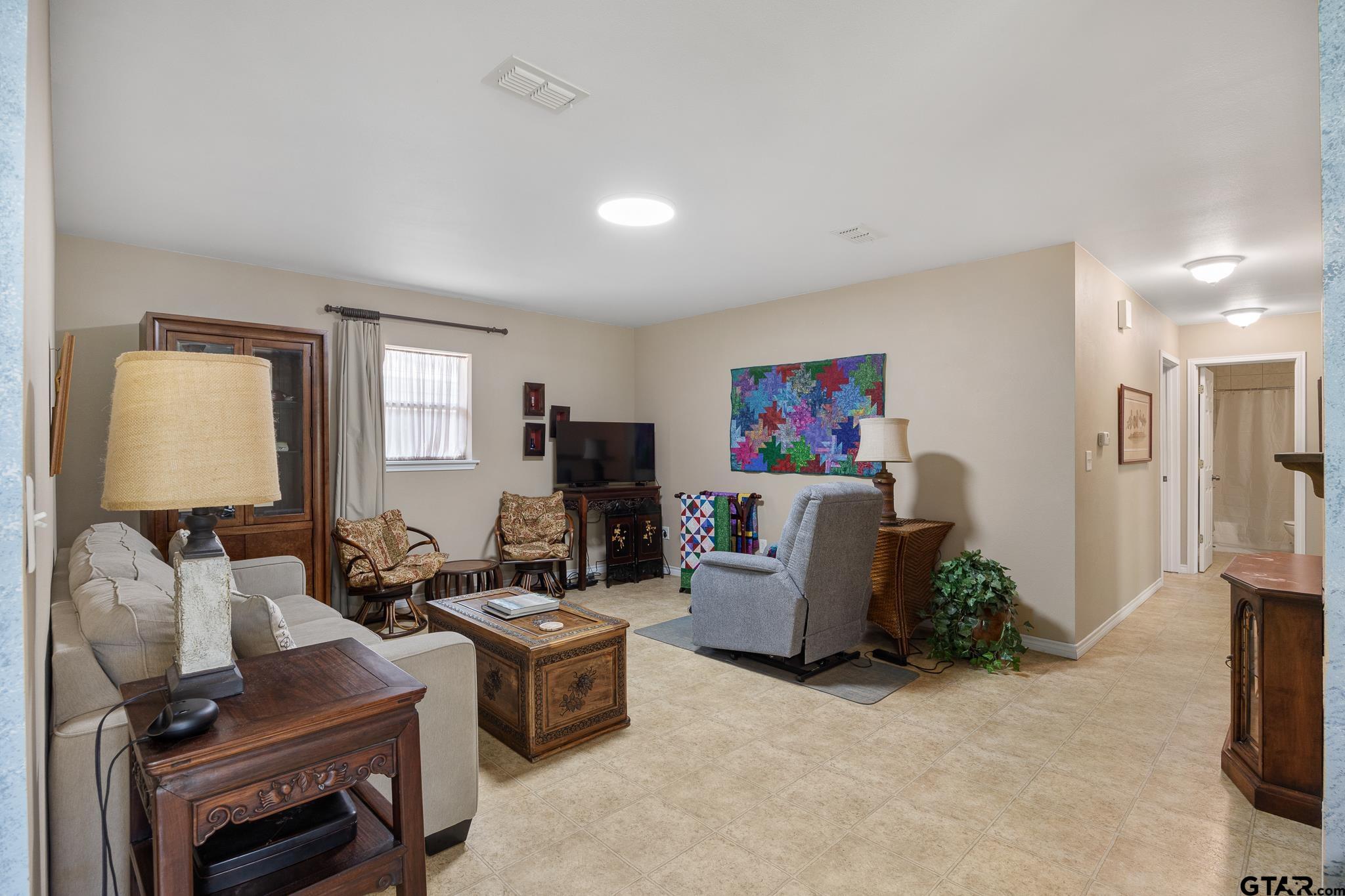 20650 West Grove Club Lake Road Whitehouse, TX 75791 - Photo 17 of 39 a living room with furniture a flat screen tv and a window
