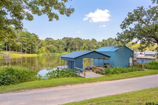 a front view of a house with a yard and large trees