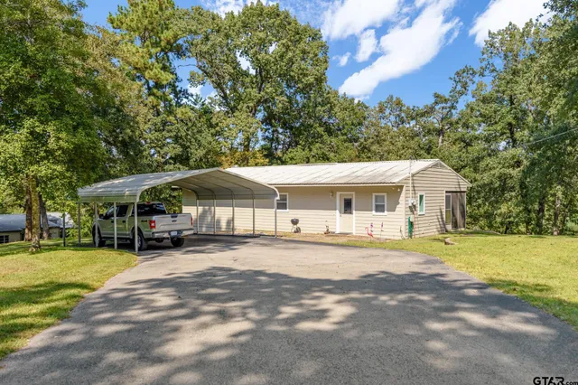 a front view of a house with a yard and trees