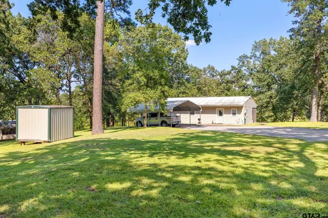 a front view of a house with a yard and trees