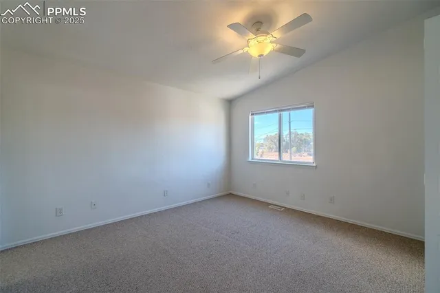 an empty room with a window and a fan