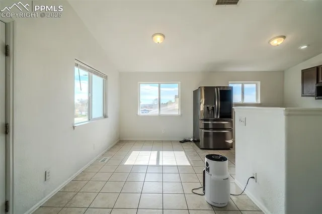 a view of kitchen with cabinets and refrigerator