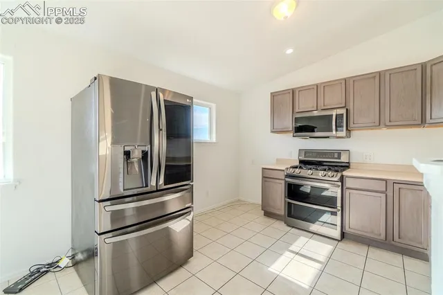 a kitchen with stainless steel appliances granite countertop a refrigerator stove and microwave