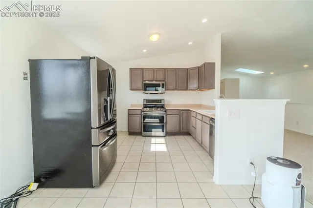 a kitchen with stainless steel appliances granite countertop a refrigerator and a stove top oven