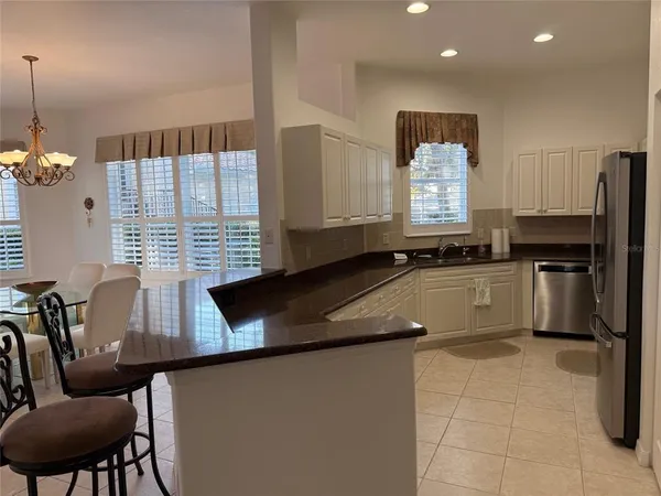 a kitchen with granite countertop stainless steel appliances a refrigerator a stove a sink and a window