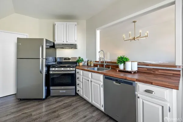 a kitchen with a refrigerator and a stove top oven