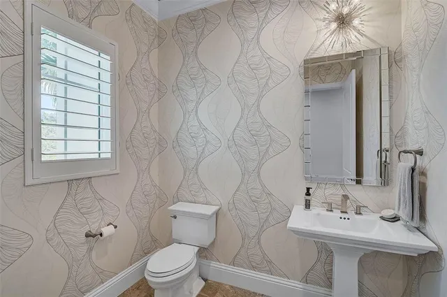 a view of a white house with a big yard and palm trees