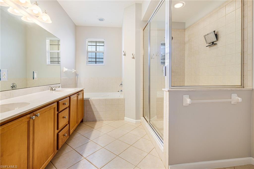 19081 Ridgepoint Drive, Unit 201 Estero, FL 33928 - Photo 13 of 42 a spacious bathroom with a double vanity sink a mirror and a bathtub