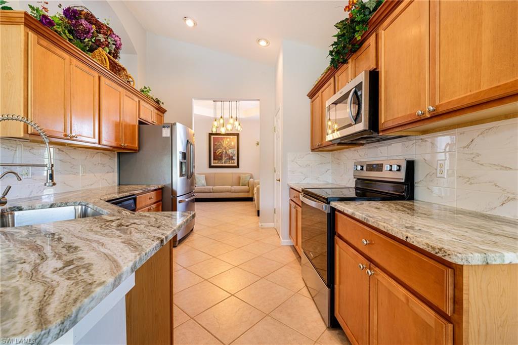 19081 Ridgepoint Drive, Unit 201 Estero, FL 33928 - Photo 2 of 42 a kitchen with stainless steel appliances granite countertop a sink stove and cabinets