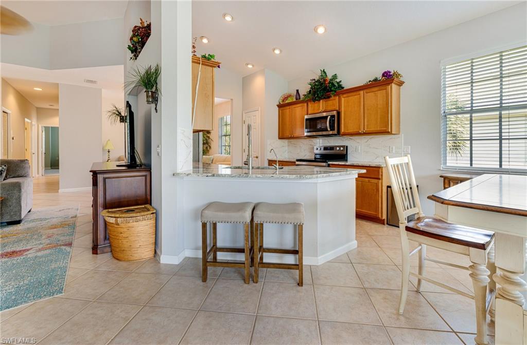 19081 Ridgepoint Drive, Unit 201 Estero, FL 33928 - Photo 3 of 42 a kitchen with stainless steel appliances granite countertop a sink a stove and a refrigerator
