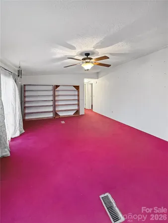 a view of empty room with fireplace and fan