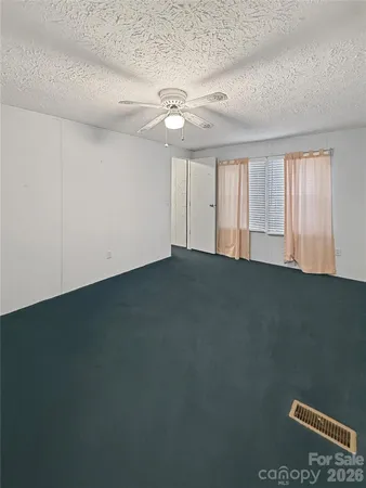 an empty room with a ceiling fan and window