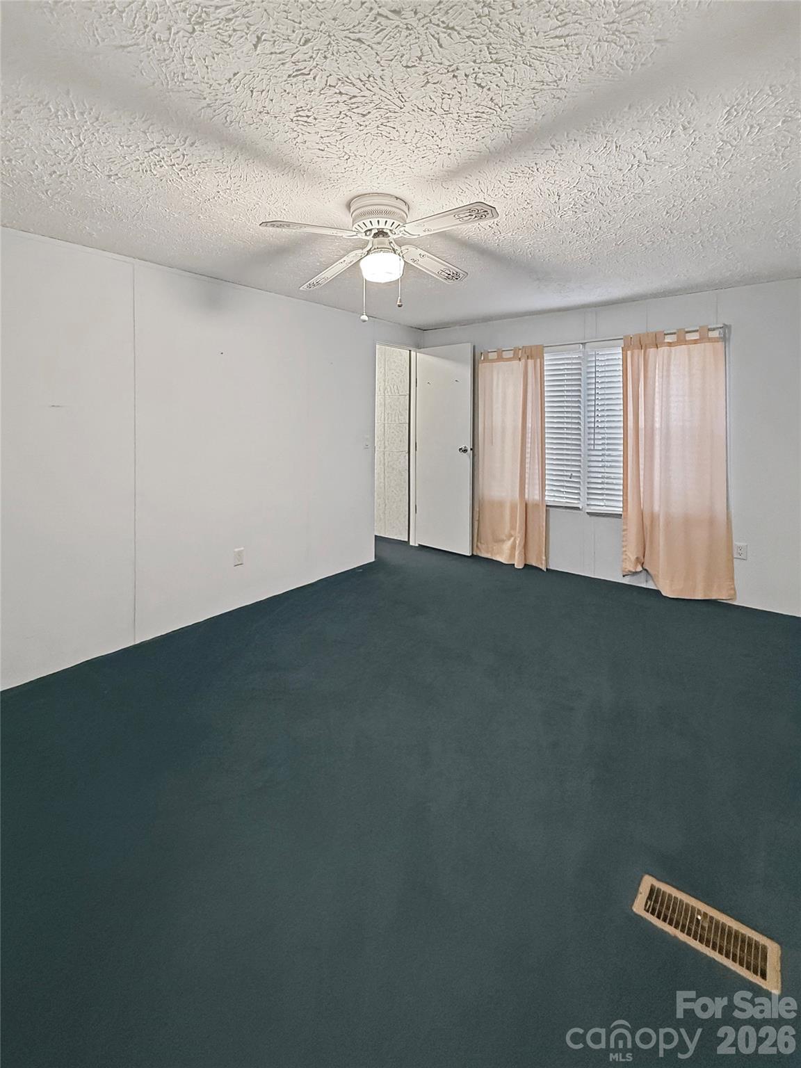 121 Haystack Lane Olin, NC 28660 - Photo 22 of 23 an empty room with a ceiling fan and window