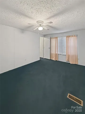 an empty room with a ceiling fan and window