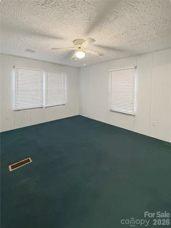 en empty room with windows and ceiling fan