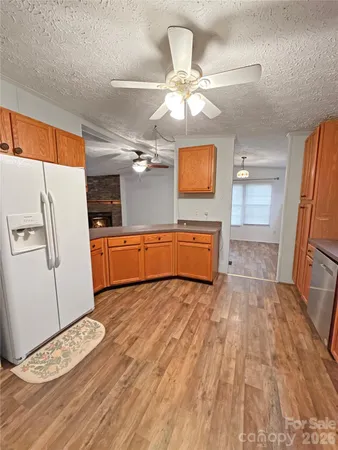 a view of a kitchen with a sink cabinet a ceiling fan and wooden floor