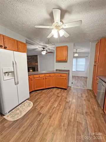 a view of a kitchen with a sink cabinet a ceiling fan and wooden floor