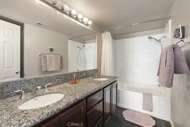 a bathroom with a granite countertop sink a toilet a mirror and shower