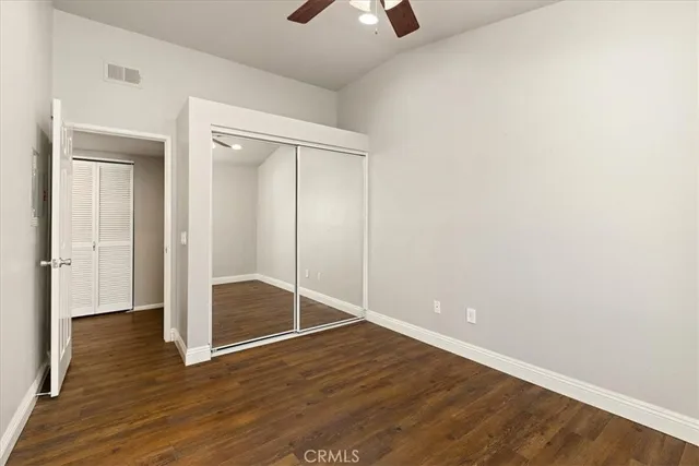 an empty room with wooden floor and closet