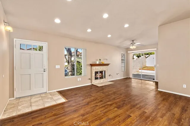 a view of an empty room with window and wooden floor