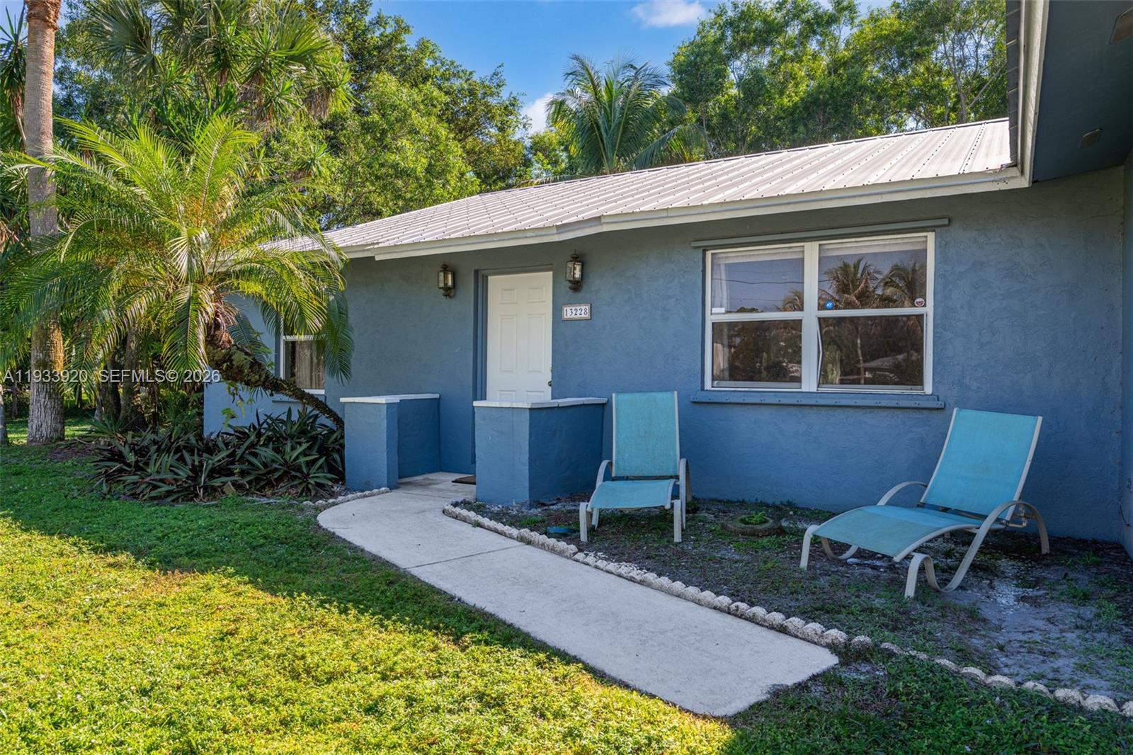 13228 158th Street North Jupiter, FL 33478 - Photo 18 of 21 a view of a chair and table in backyard of the house