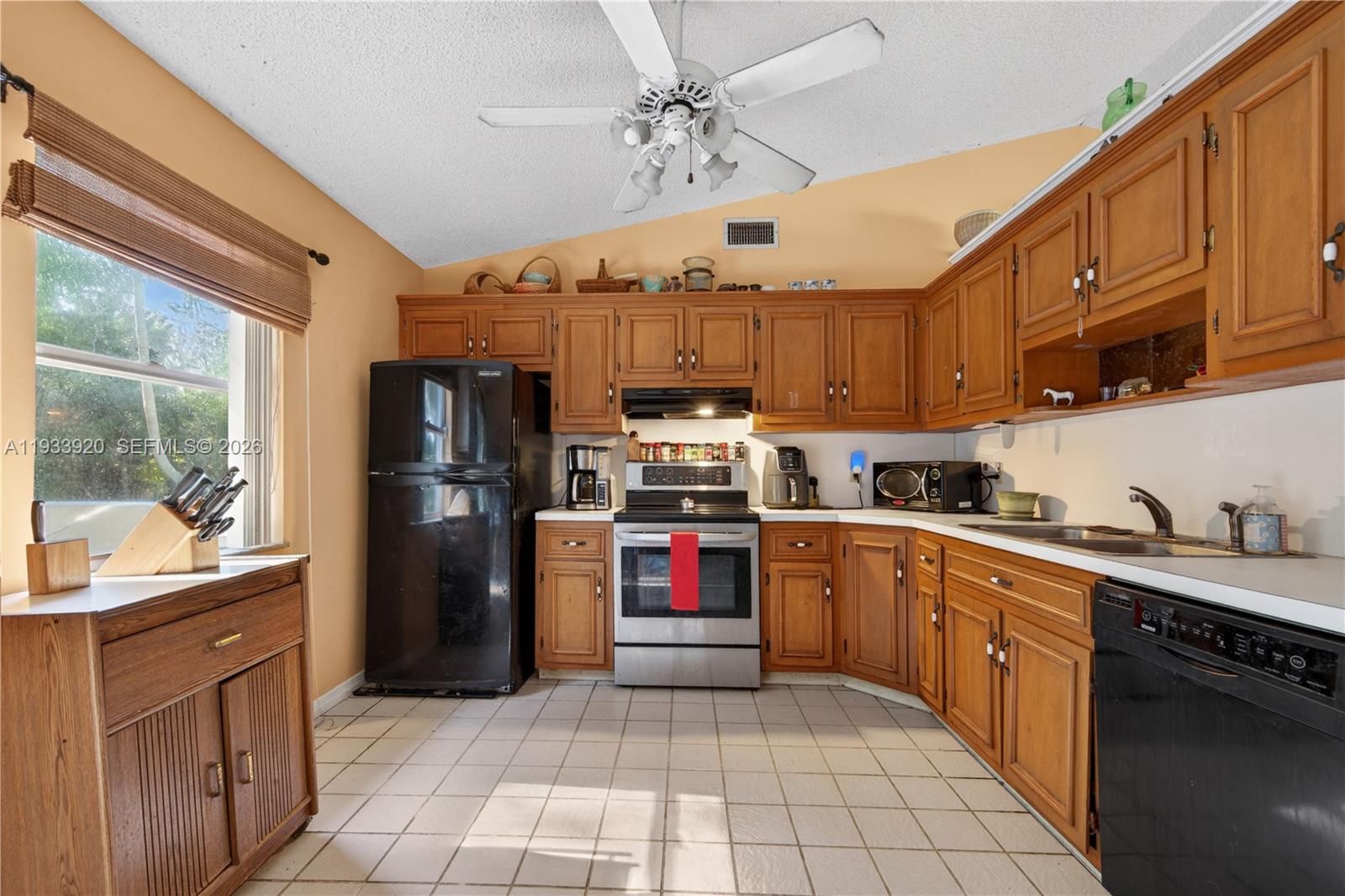 13228 158th Street North Jupiter, FL 33478 - Photo 8 of 21 a kitchen with granite countertop a refrigerator and a stove top oven