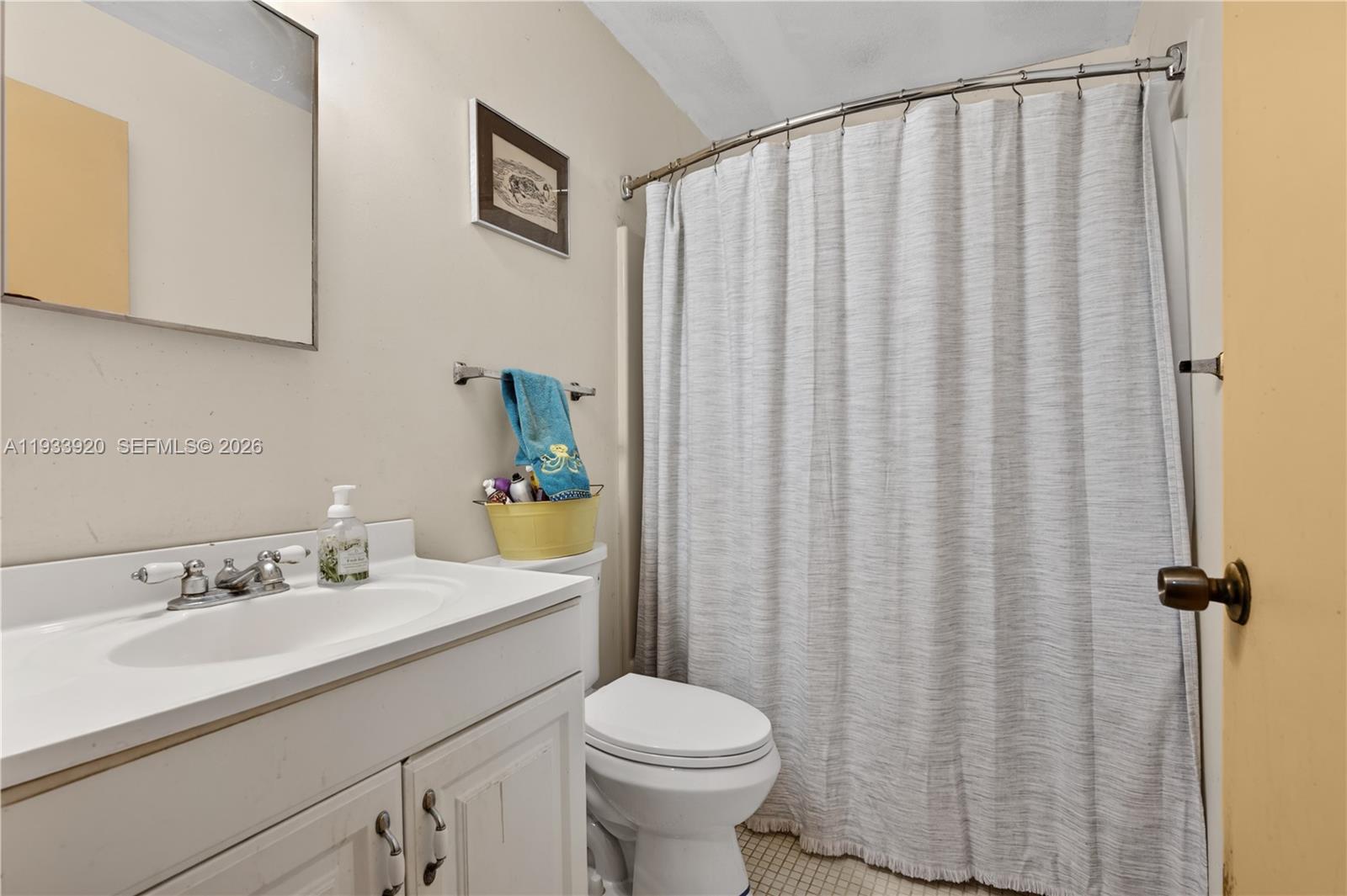 13228 158th Street North Jupiter, FL 33478 - Photo 10 of 21 a bathroom with a sink a toilet and shower curtain