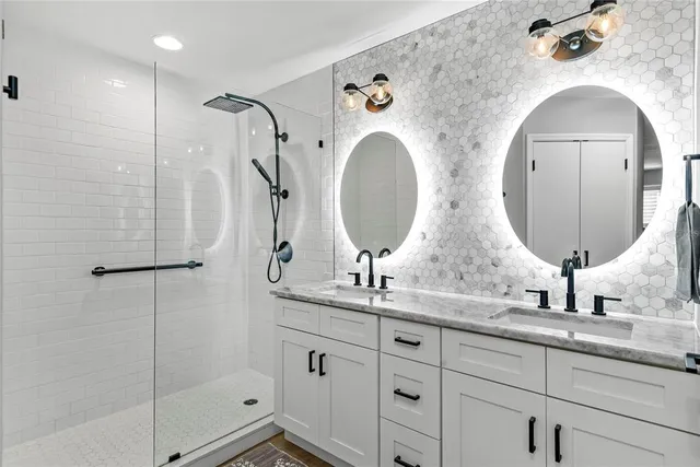 a bathroom with double vanity sinks and a mirror