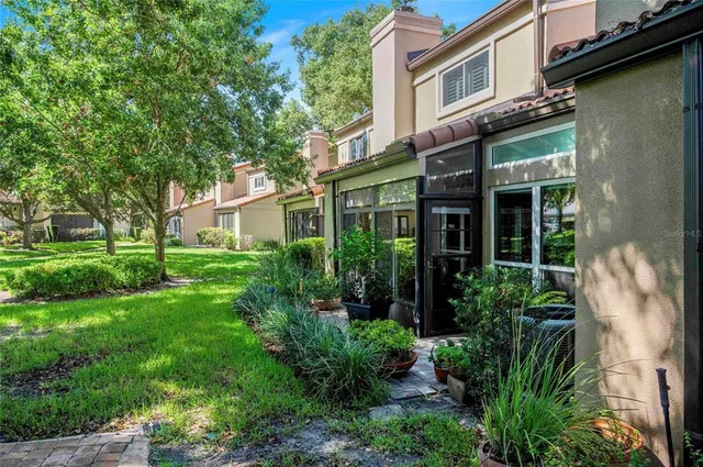 a view of a house with brick walls and a large tree