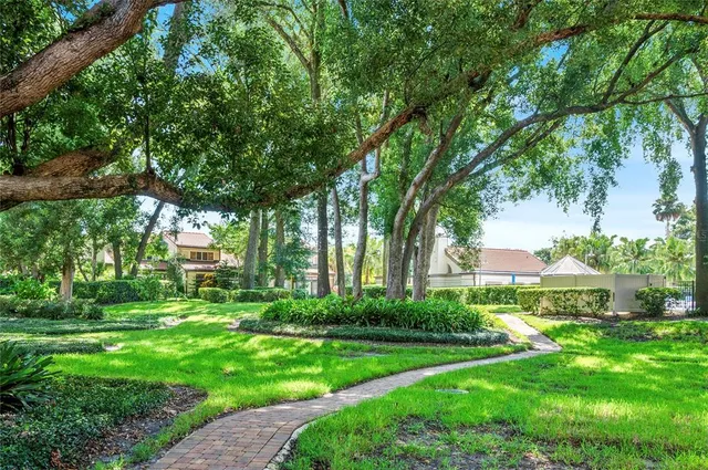 a view of a house with a big yard and large trees