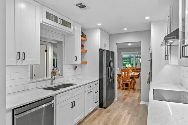 a kitchen with stainless steel appliances granite countertop a refrigerator and a sink