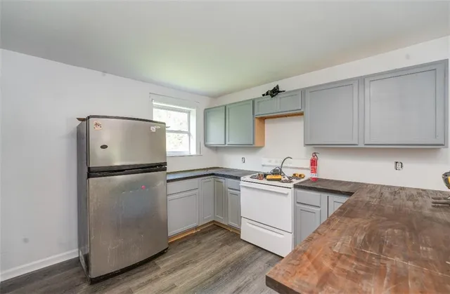 a kitchen with a sink a refrigerator and white cabinets