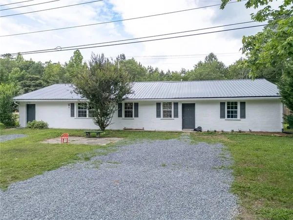 a front view of a house with a yard and trees