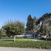 a view of big yard with a house in the background