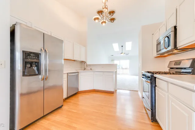 a kitchen with cabinets stainless steel appliances and sink