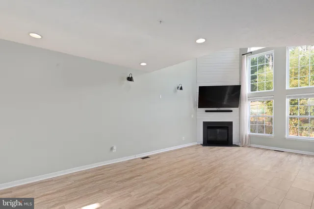 a view of empty room with a fireplace and window