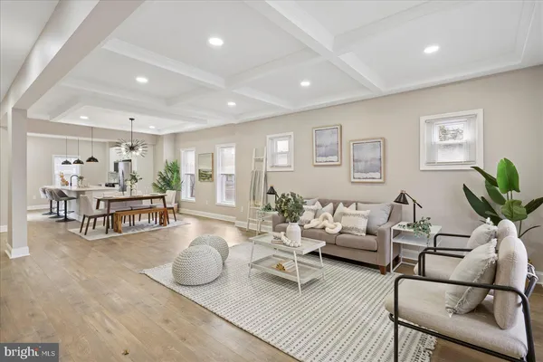 a living room with furniture and a dining table with wooden floor