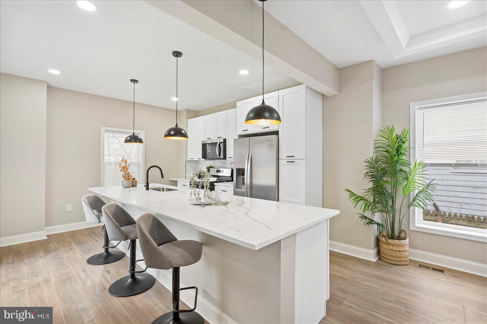 3925 Norfolk Avenue Baltimore, MD 21216 - Photo 12 of 49 a kitchen with granite countertop a table chairs sink and wooden floor