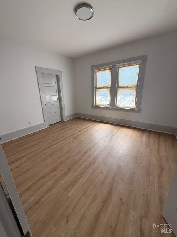 839 Capitol Street Vallejo, CA 94590 - Photo 4 of 8 an empty room with wooden floor and windows