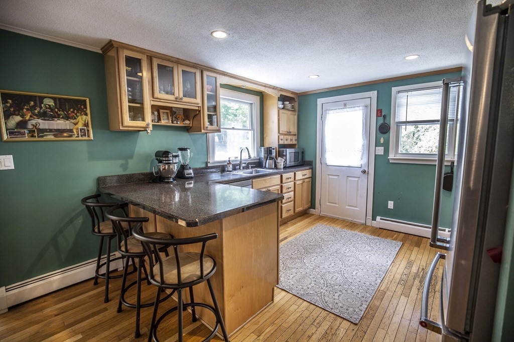 58 Lancaster Road Shirley, MA 01464 - Photo 6 of 31 a kitchen with a table chairs and wooden floor