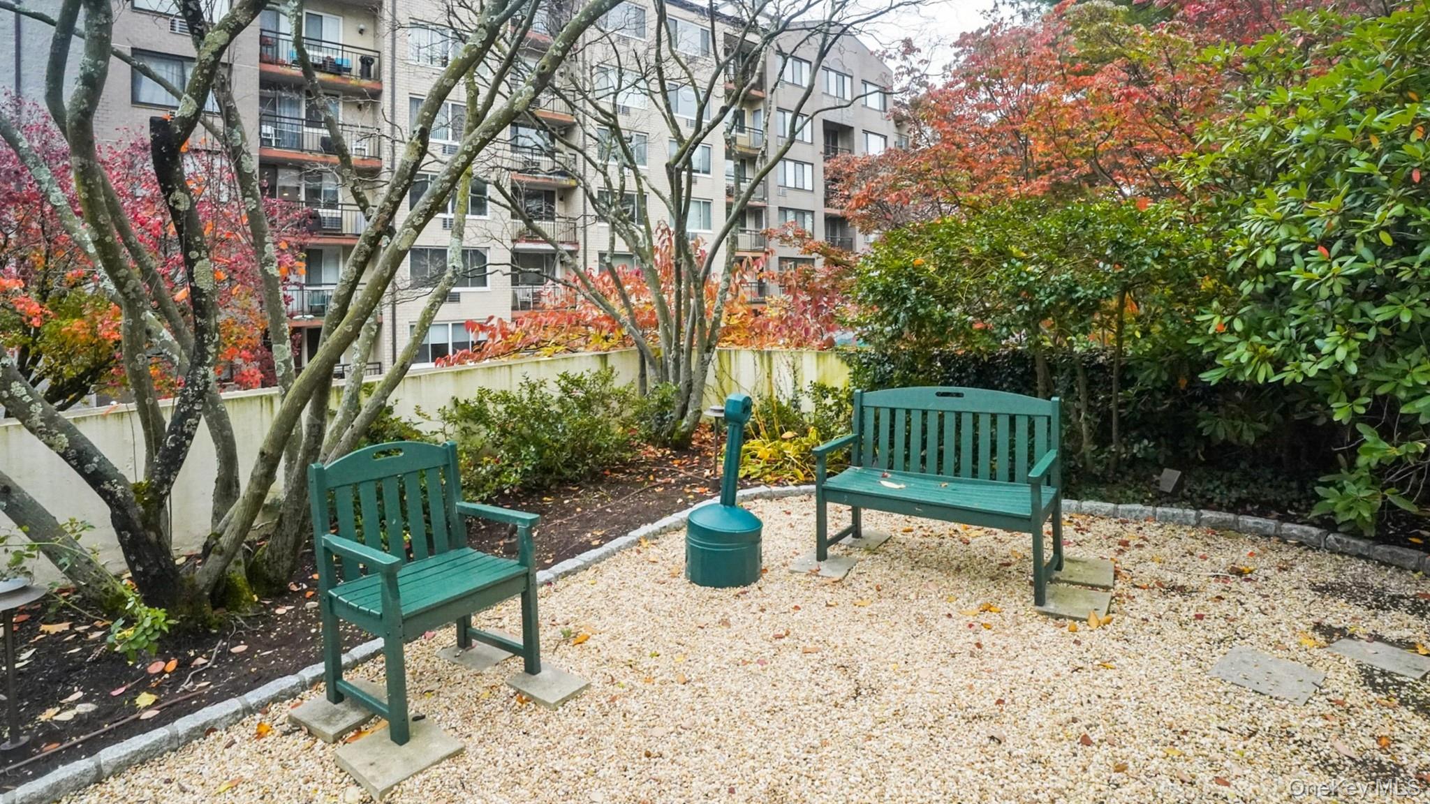 703 Pelham Road, Unit 107 New Rochelle, NY 10805 - Photo 13 of 14 a view of a bench in a garden