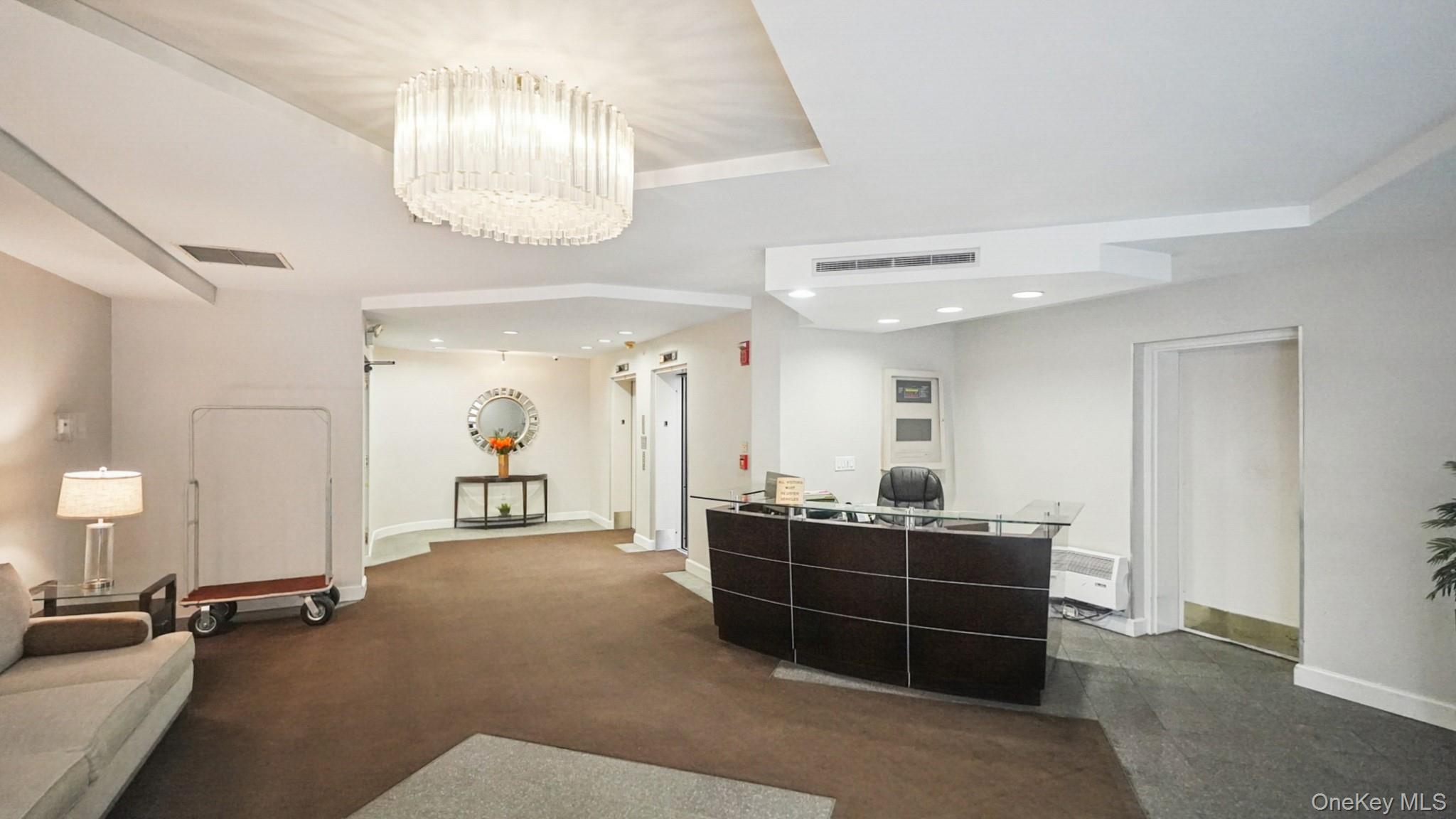 703 Pelham Road, Unit 107 New Rochelle, NY 10805 - Photo 2 of 14 a room with a bed and a chandelier