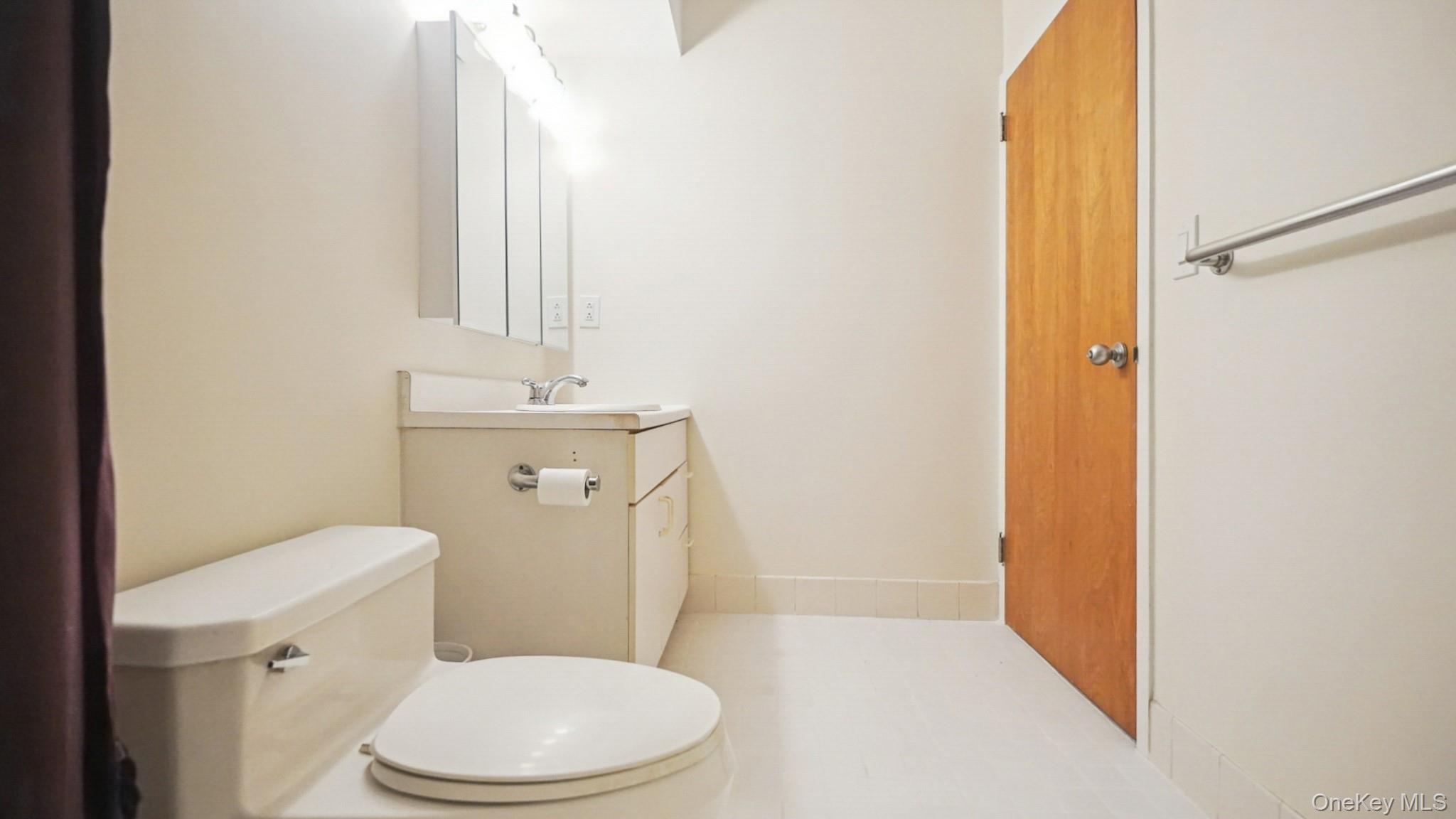 703 Pelham Road, Unit 107 New Rochelle, NY 10805 - Photo 6 of 14 a white toilet sitting next to a bathroom sink