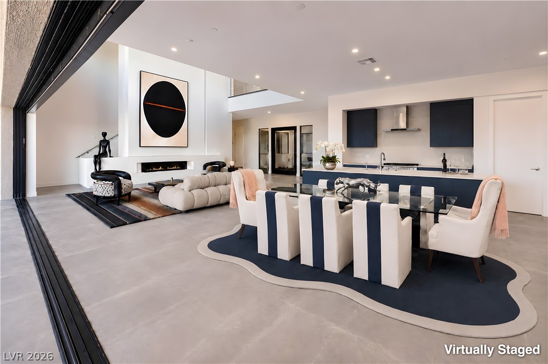 25 Falling Ridge Lane Henderson, NV 89011 - Photo 48 of 48 An open floorplan seamlessly connects the well-lit living area, contemporary fireplace, and a sleek kitchen.