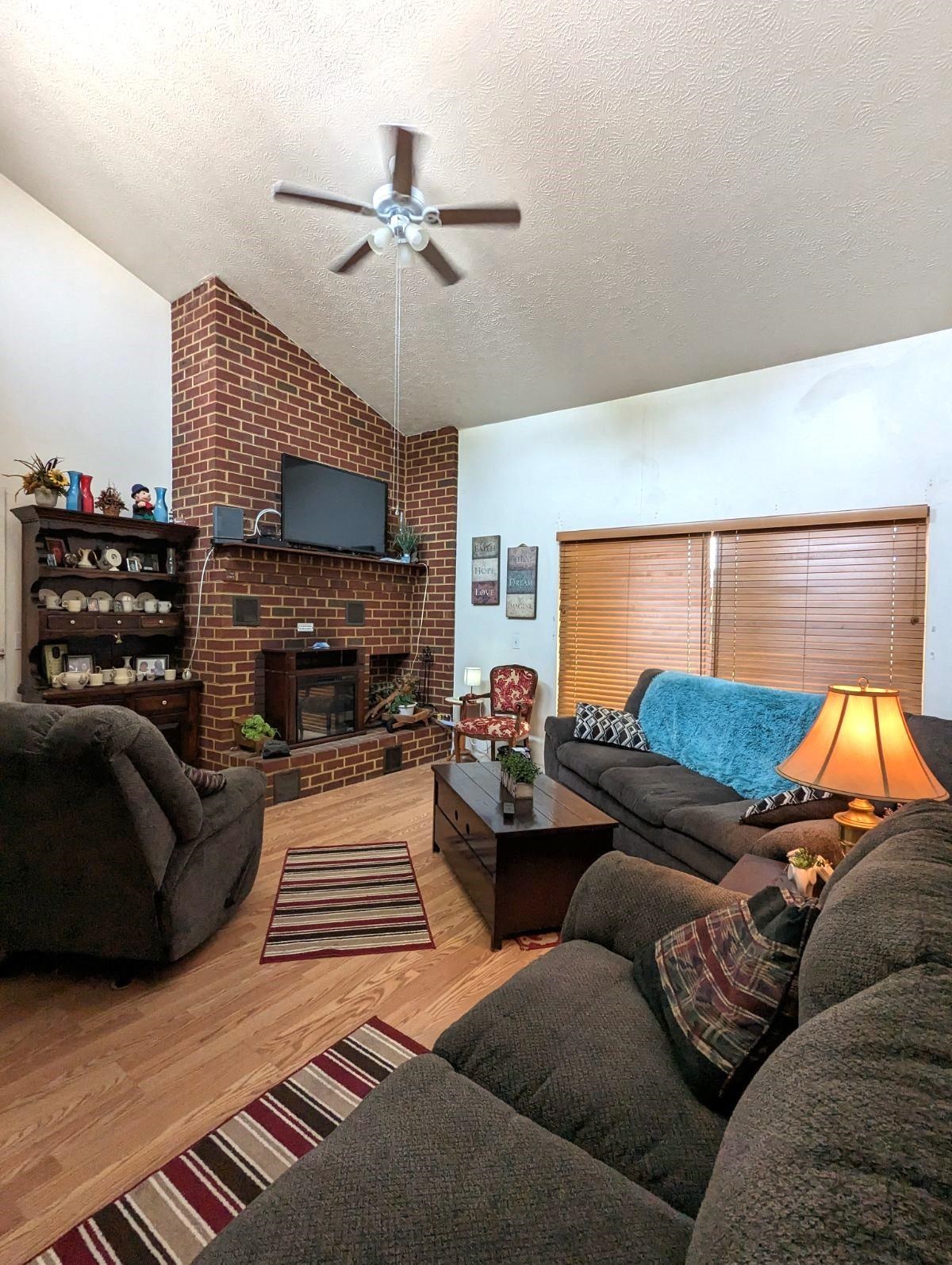 1112 Blue Ridge Drive, Unit 9 Harrisonburg, VA 22802 - Photo 2 of 13 a living room with furniture a ceiling fan and a fireplace